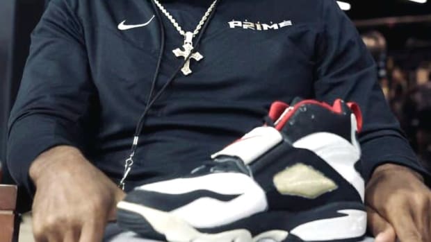 Deion Sanders holding a Diamond Turf shoe